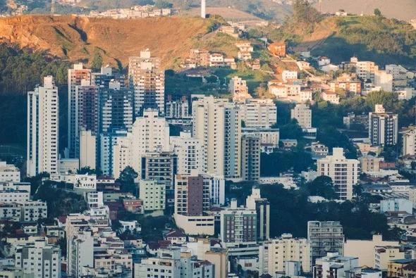 Vista aérea da cidade de Juiz de Fora MG. Prédios e casas cercadas pelo verde das montanhas.